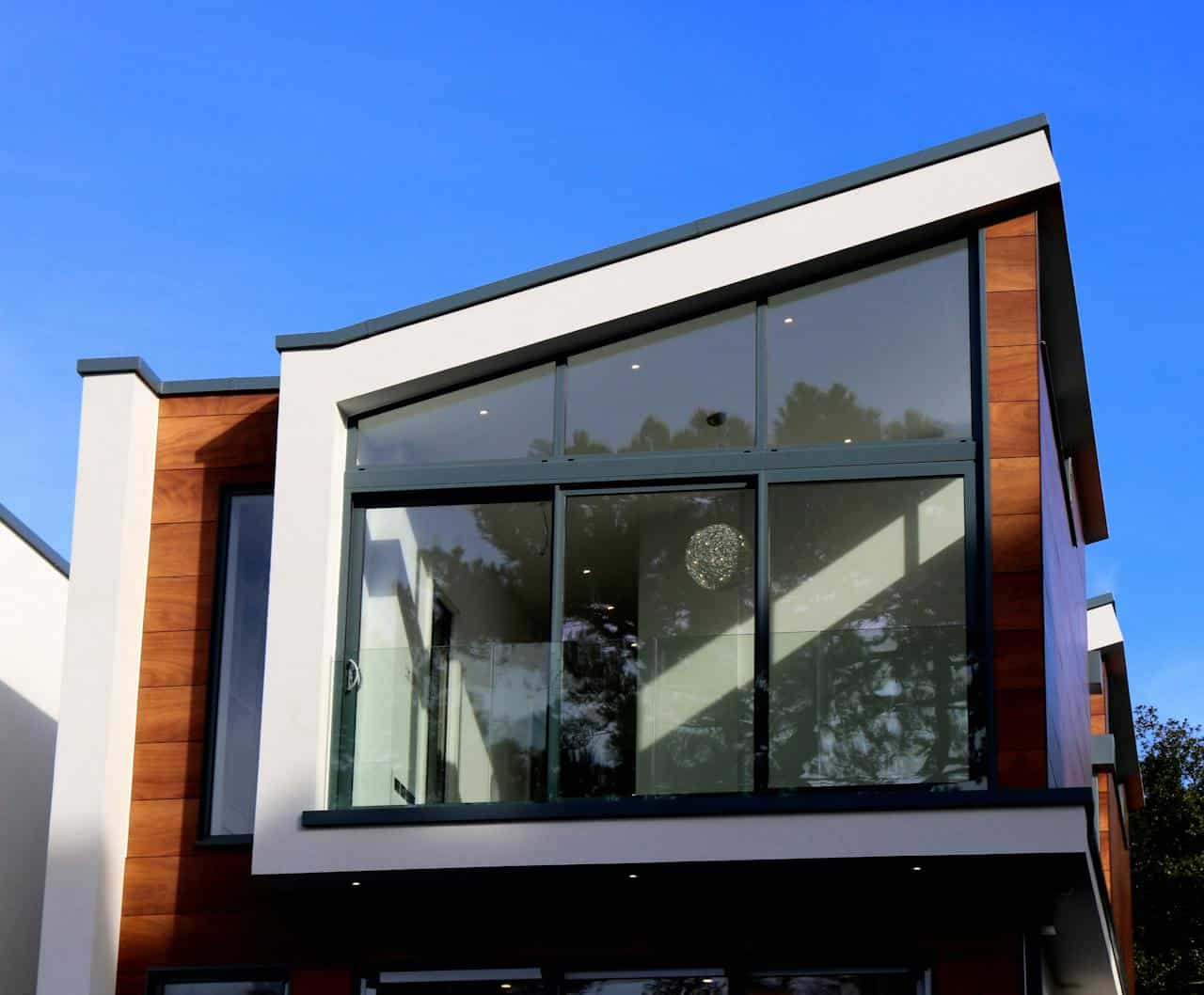 hero-img-01 Contemporary house in Poole, UK featuring a sleek design with large glass windows and wood paneling.